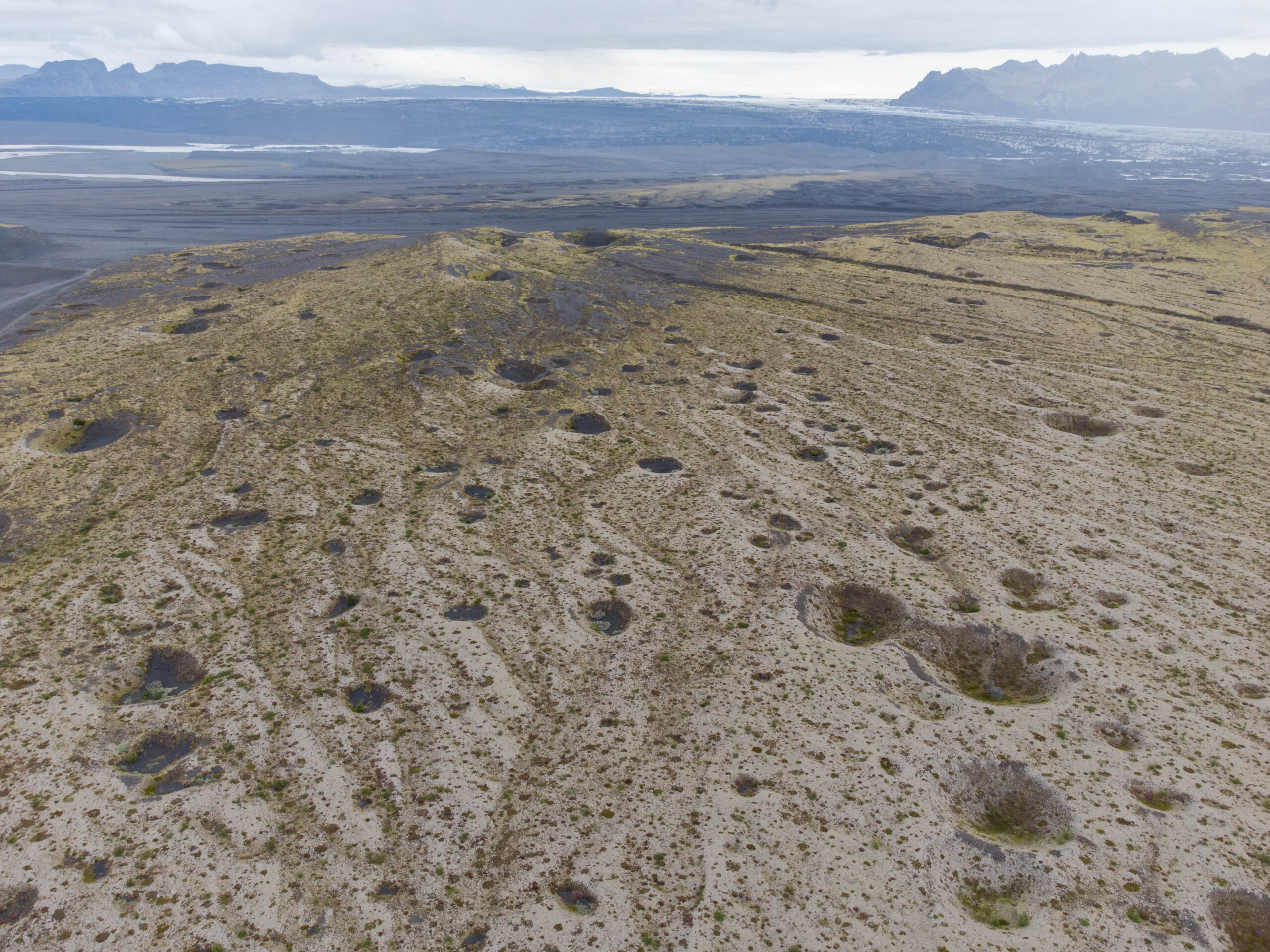Landschap vol doodijsgaten met de Skeiðarárjökull op de achtergrond, augustus 2023. Deze kuilen dateren van een eerdere jökulhlaup, mogelijk 1903.