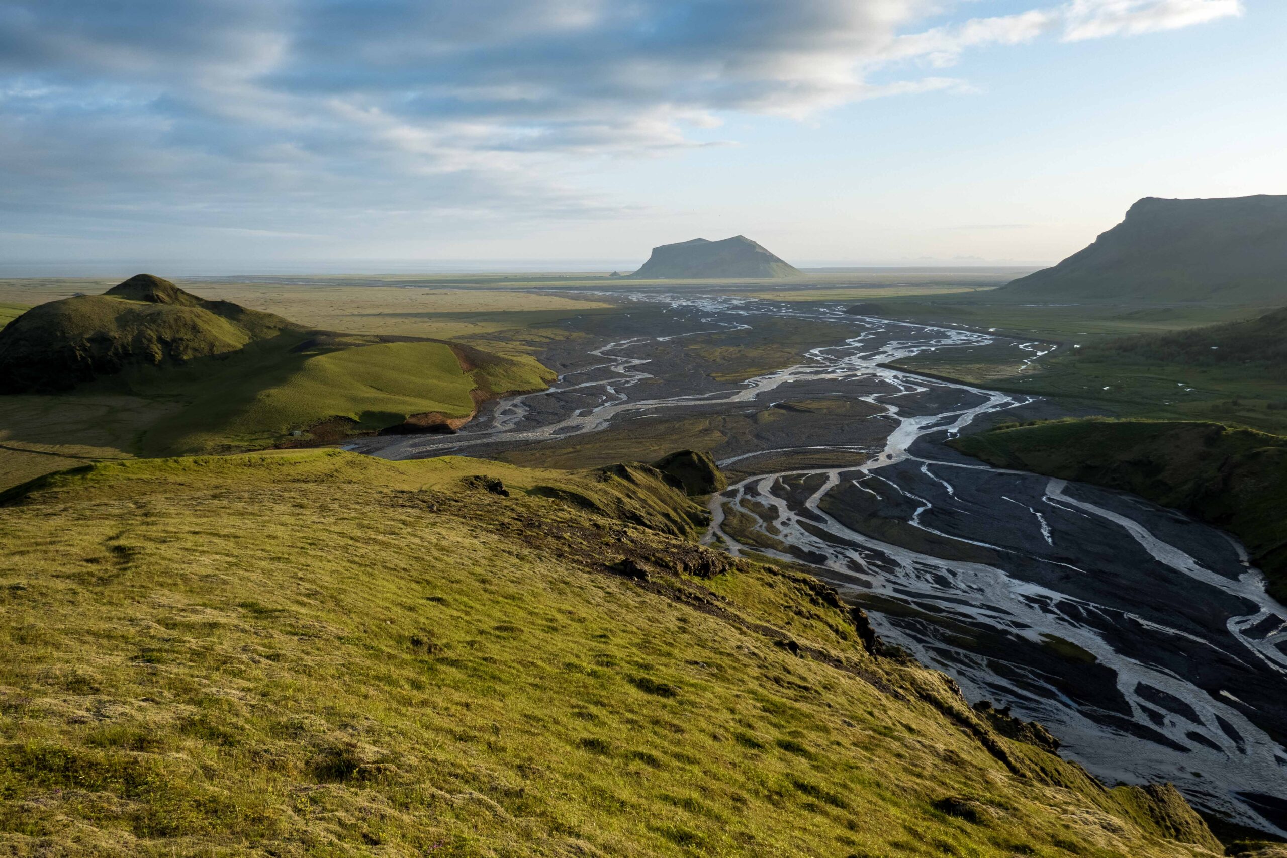 De Kambá vanaf Stórhöfði, juli 2023. De vrijstaande heuvel Pétursey op de achtergrond.