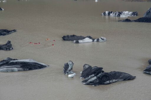 Kajakkers tussen de ijsbergen op het gletsjermeer van Sólheimajökull, juli 2023.