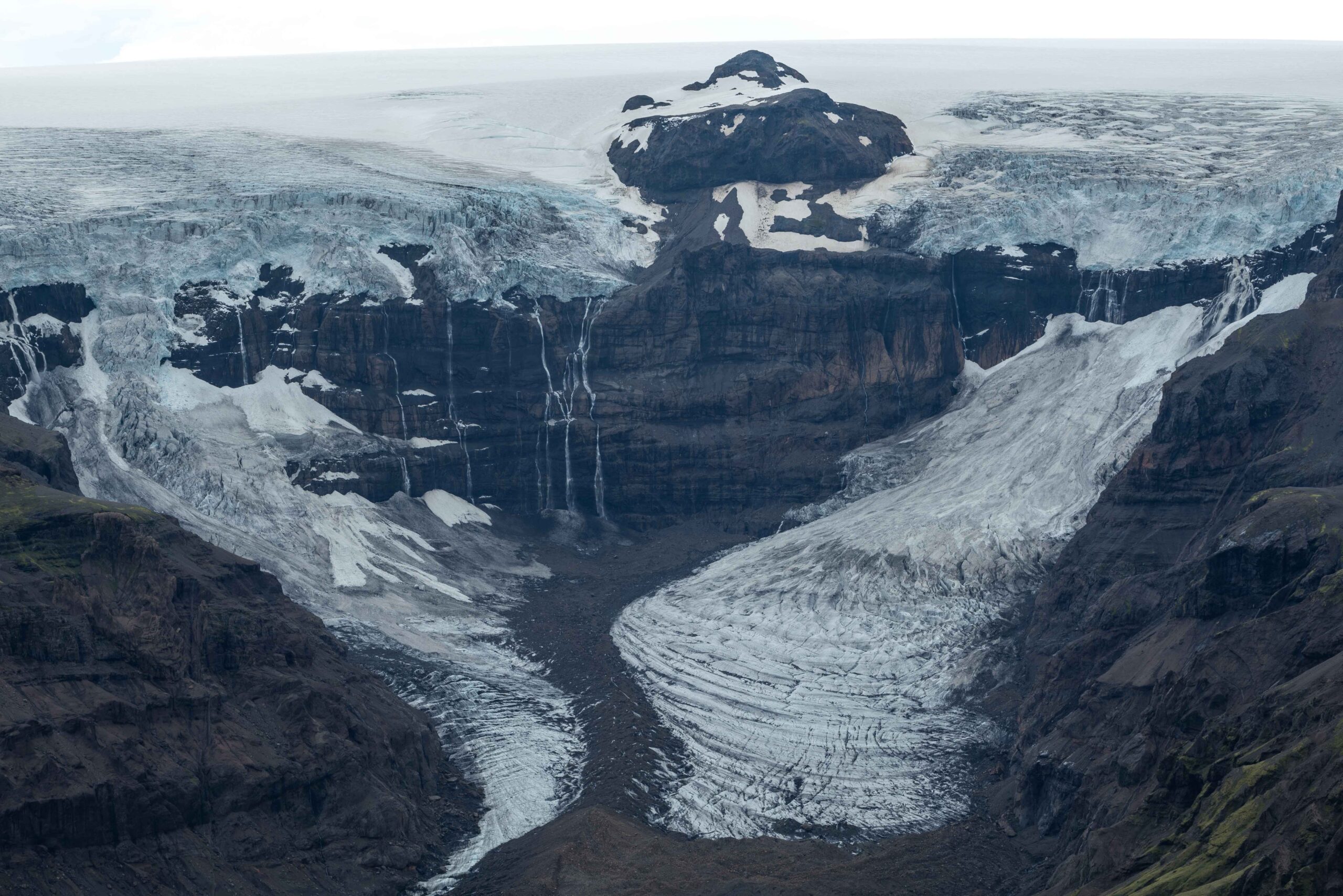 De ijsval (links) en ijslawine (rechts) van de Morsárjökull, juni 2023.