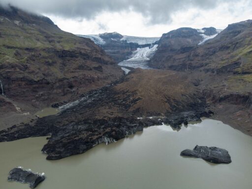 Luchtfoto van de Morsárjökull, die grotendeels schuil gaat onder de stenen van de rotslawine uit 2007 (lichtbruin), augustus 2023.