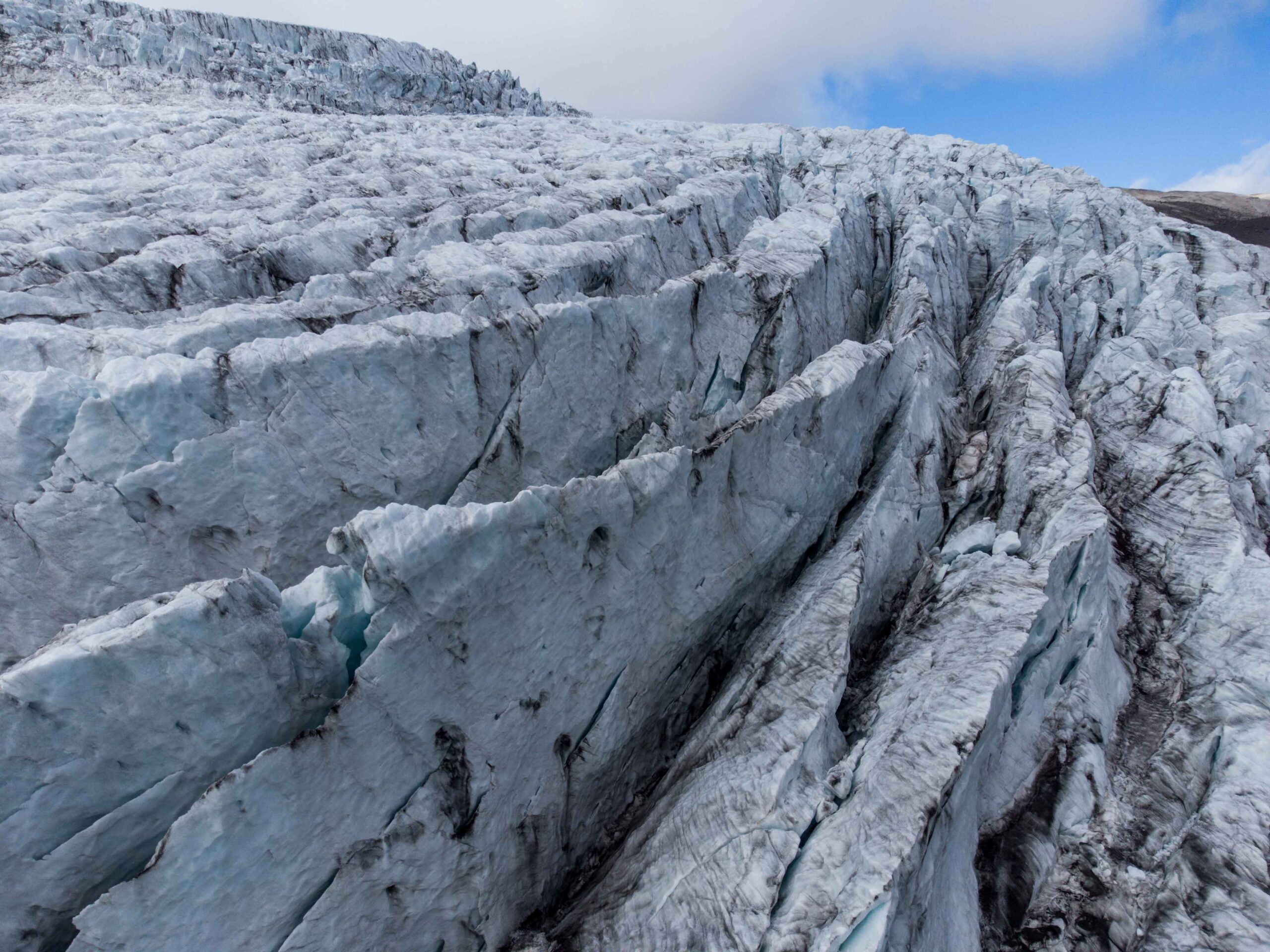 Op de plek waar de Stigárjökull over de klif heen valt zitten er diepe crevassen in het ijs, augustus 2023 (dronefoto).