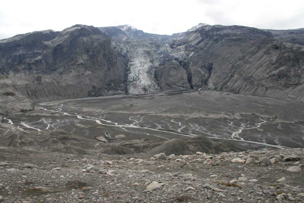 De laagte voor de Gígjökull is twee maanden na de vulkaanuitbarsting een grijze vlakte van as. Bron: Andy Rusell via Flickr.