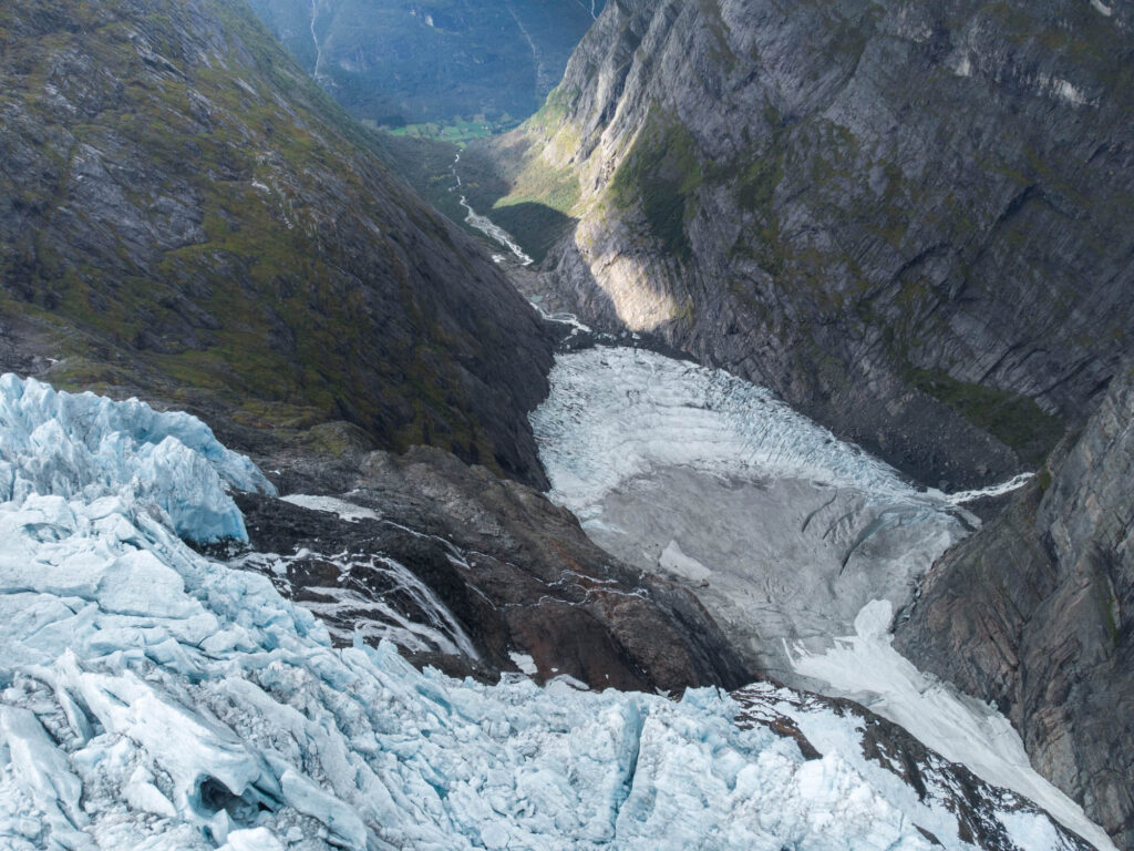 Ice falls down to form a new glacier at the foot of the cliff.