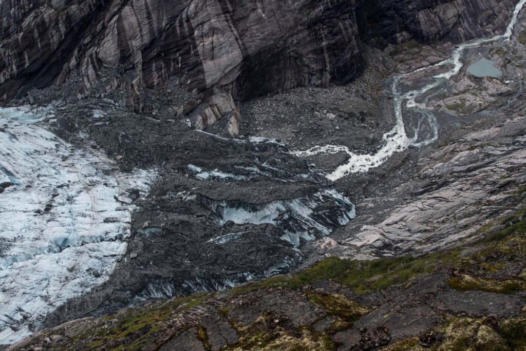 The front part of the glacier snout is covered by rocks.