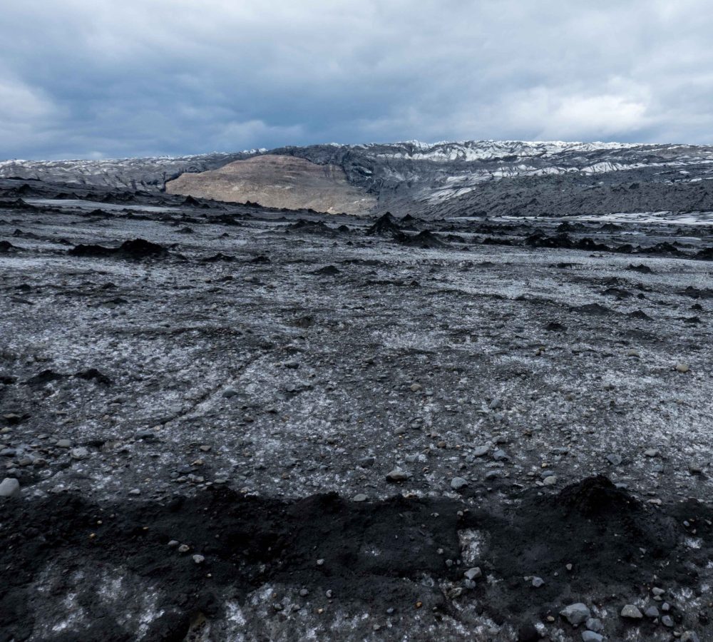 Een rots komt uit de dunner wordende gletsjer tevoorschijn, juni 2023.